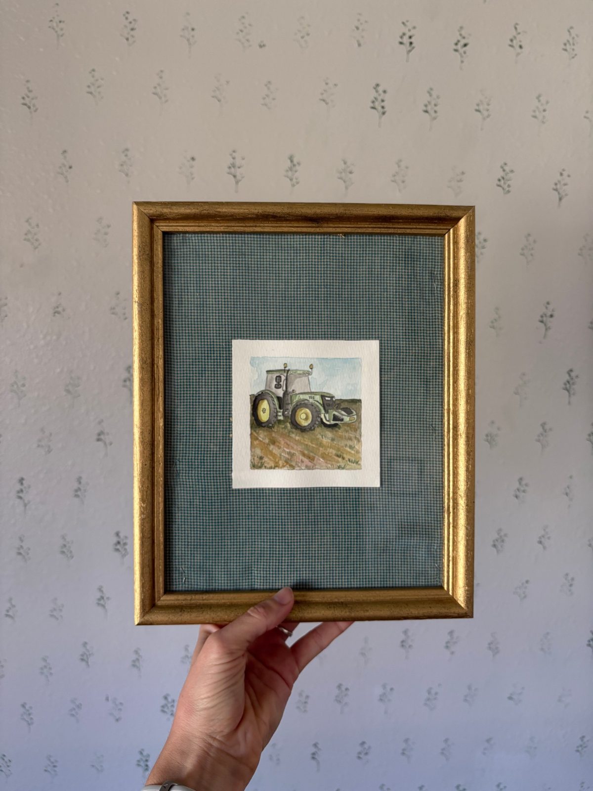 Framed watercolor of a tractor in a field